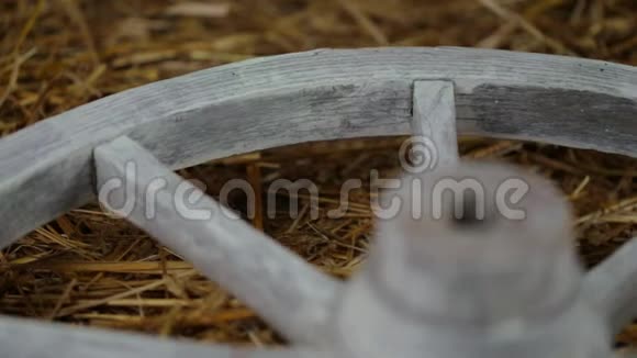 一个古老的白色木轮躺在干草和旋转视频的预览图
