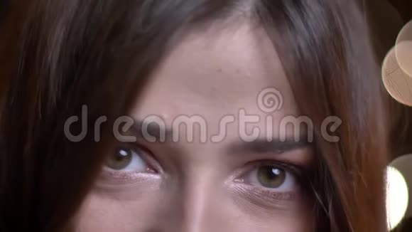 年轻漂亮的白种人女性脸上的特写镜头绿色的眼睛神秘地凝视着镜头视频的预览图