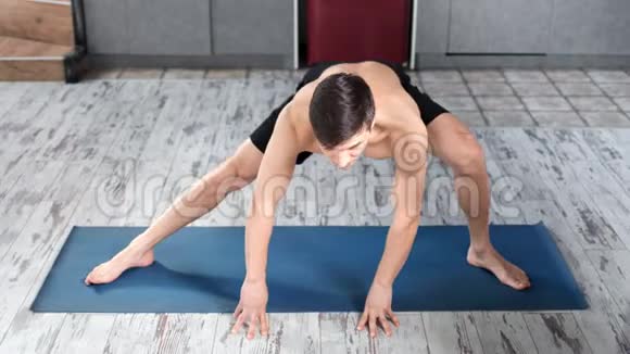 健身年轻人喜欢在木地板高角度的垫子上做身体伸展运动视频的预览图