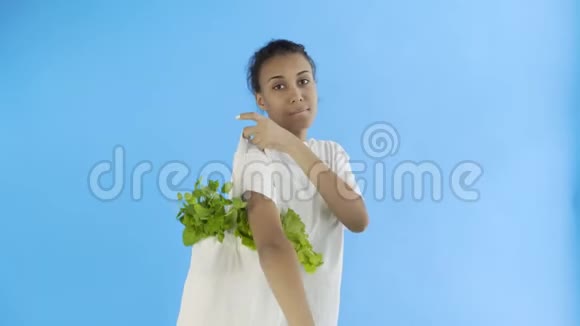 女人拿着蓝底蔬菜包视频的预览图