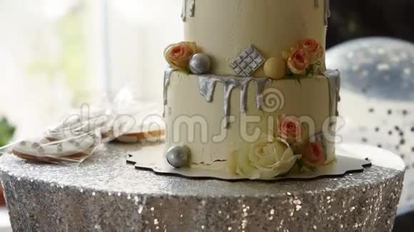 婚礼蛋糕与玫瑰白色釉和银顶在糖果棒生日派对提供蛋糕饼干和饼干视频的预览图