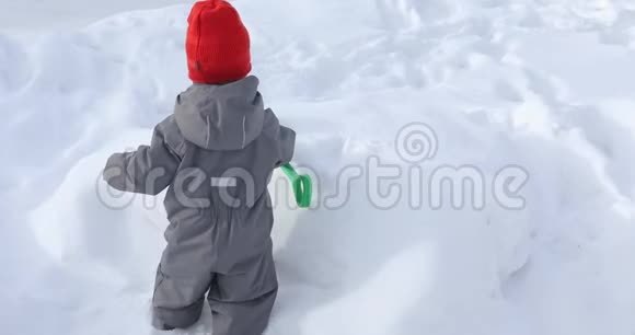 小男孩用铲子挖雪堆视频的预览图