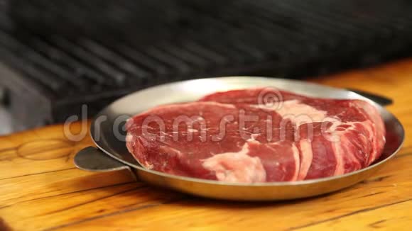 牛排牛肉撒上粗盐和胡椒然后送到烤架上视频的预览图
