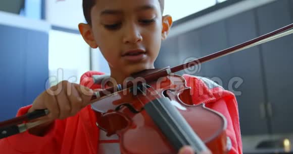 亚洲学生专心致志在4k教室拉小提琴的正面景色视频的预览图