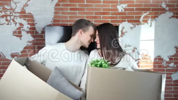 一对幸福的年轻夫妇在移动时拿着一个装有物品的拆包箱视频的预览图