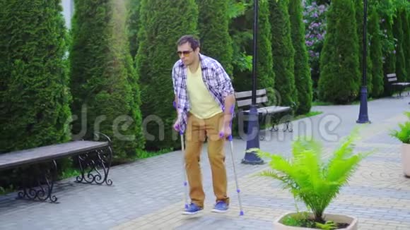阳光明媚的一天一个拄着拐杖走路的时髦男人视频的预览图