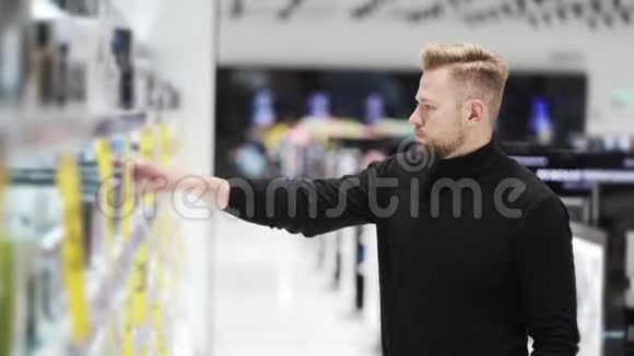 年轻的帅哥在化妆品店挑选商品购物理念视频的预览图
