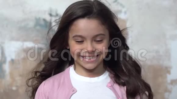 一个小女孩独自被隔离在墙上微笑着快乐视频的预览图