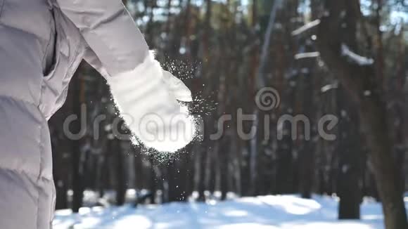 无法辨认的女人戴着白手套拍手雪花飘落下来女孩站在冬天的森林里玩耍视频的预览图