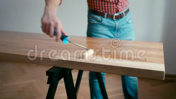 木匠用油整理木制橡木桌家中有滚筒视频的预览图