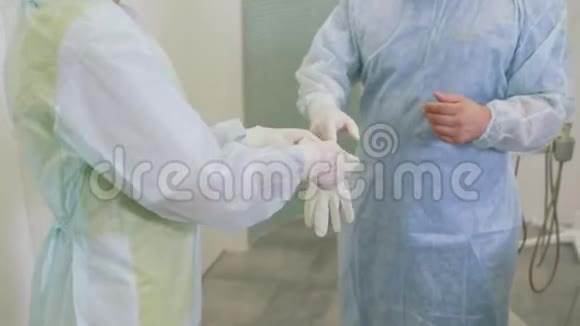 护士帮助外科医生在医院进行硬化手术前戴上无菌手套视频的预览图