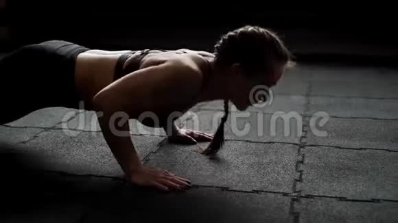 运动的女人在地板上做俯卧撑在健身房里慢动作地做着视频的预览图