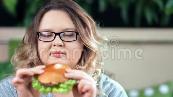 体贴专注的节食胖女人怀疑看新鲜开胃的汉堡特写视频的预览图