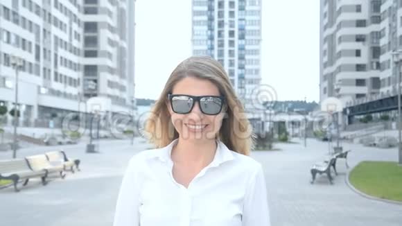 现代都市中一个戴墨镜的金发美女的肖像视频的预览图