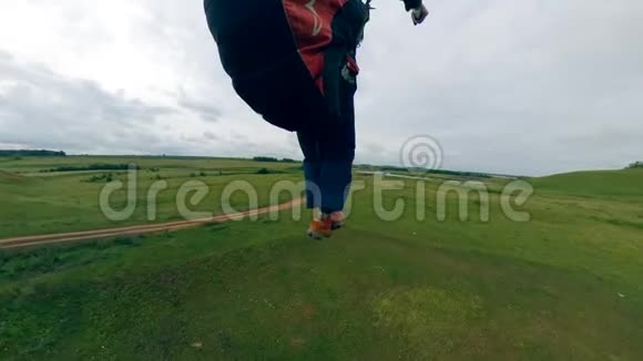 运动员用滑翔机飞行降落在绿色的田野上视频的预览图