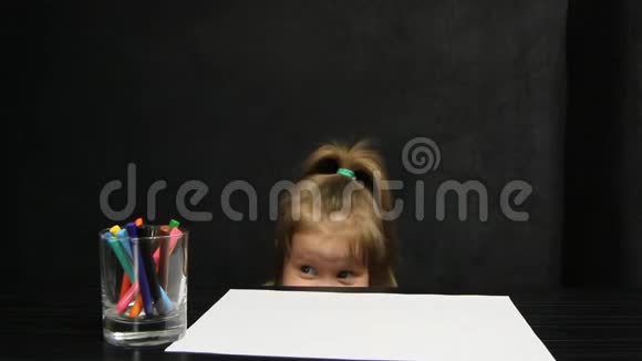 小女孩躲在桌子下面画画也许她害怕什么视频的预览图