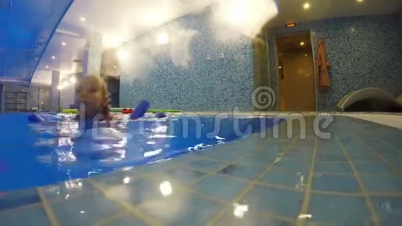 这个女孩正在游泳池里用水上运动器材训练视频的预览图