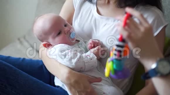 小宝宝躺在妈妈的手臂上看玩具视频的预览图