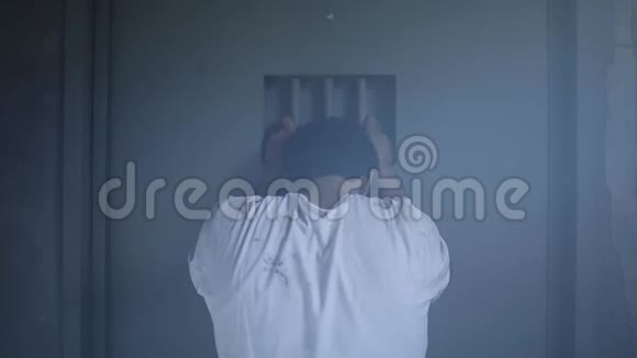 一个沮丧的囚犯站在监狱门口视频的预览图