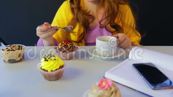 桌旁咖啡馆的女孩喝绿茶用勺子吃蛋糕视频的预览图