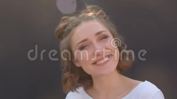 一位年轻漂亮的白种人女性的特写镜头她的头发包在镜头前笑着开心地摆姿势视频的预览图
