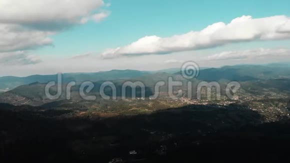 美丽的青山在蓝天上高高耸立着无人机沿山谷飞行从山上飞下来的视频的预览图
