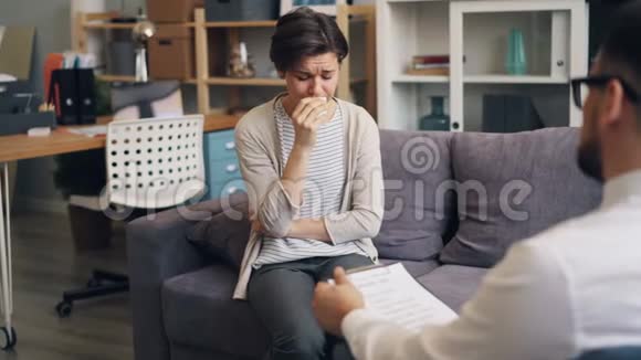 心烦意乱的病人在与办公室心理医生的私人谈话中哭泣视频的预览图