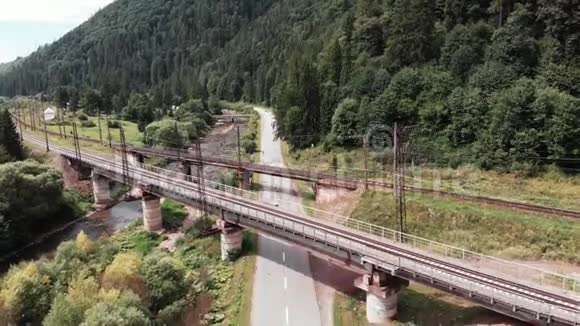 鸟瞰老混凝土铁路桥无人机在两座铁路老桥附近飞行骑自行车女孩在铁路附近骑自行车训练视频的预览图