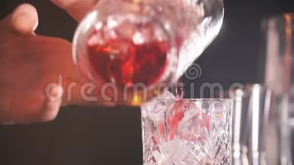 酒保男子将红宝石鸡尾酒倒入水晶玻璃视频的预览图