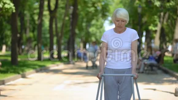 令人不安的老妇人带着步行架搬到户外创伤后康复视频的预览图