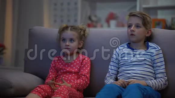 哥哥抱着吓坏了的妹妹一起晚上看恐怖片家人视频的预览图