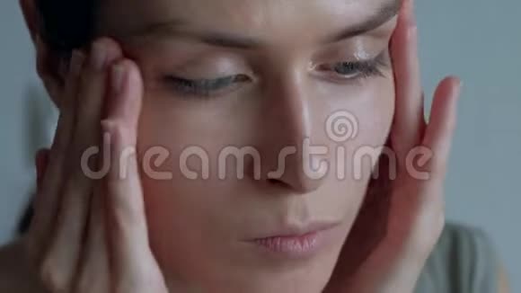 女人在脸上涂上一层粉底后抚平和按摩皮肤视频的预览图