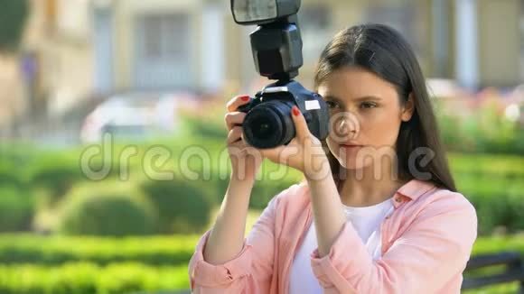 在公园里用相机拍摄的女摄影师视频的预览图