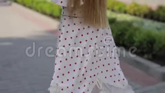 美丽的快乐女人穿着裙子在夏城小巷扔头发慢动作视频的预览图