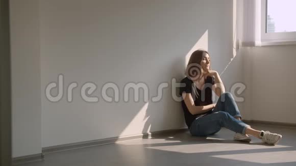 一幅年轻漂亮的白种人女性的特写照片她坐在窗边在舒适的室内愉快地微笑着视频的预览图