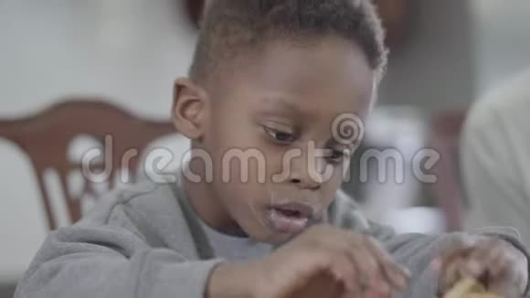 滑稽的非洲裔美国儿童的肖像在牛奶后嘴唇脏兮兮坐在桌子旁玩饼干视频的预览图