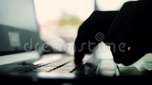 手在电脑键盘上打字的剪影一个慢动作的商人视频的预览图