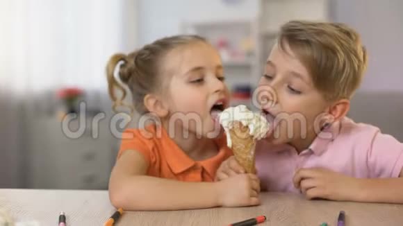 可爱的哥哥和姐姐一起吃冰淇淋坐在家里的桌子上吃东西视频的预览图