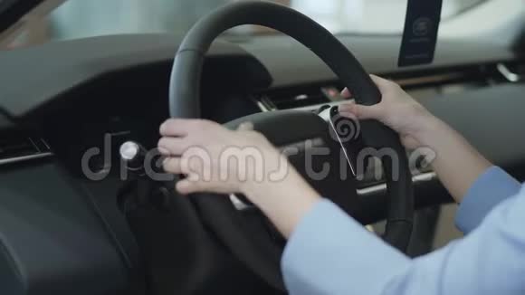 女人用手指靠近方向盘现代女孩在车展上看汽车概念视频的预览图