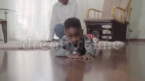 非裔美国人的母亲和小儿子在家里度过一个有趣的周末男孩爬在地板上他妈妈就在附近视频的预览图
