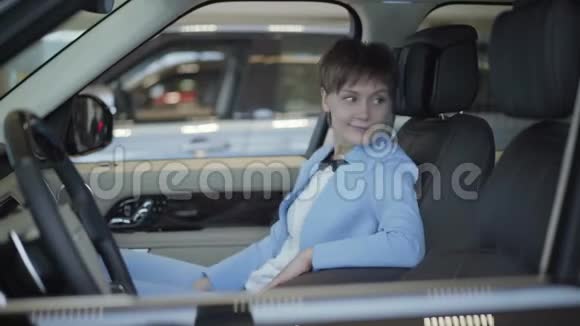 年轻女性短发正式穿着蓝色西装坐在前面的Passanger座位的车里现代女孩视频的预览图