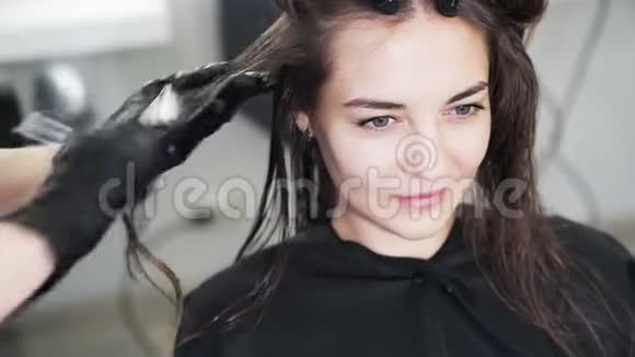 靠近理发师的手把角蛋白涂在女人湿发上视频的预览图