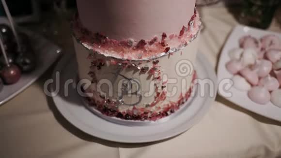 桌子上摆着一个粉红色的三层蛋糕视频的预览图