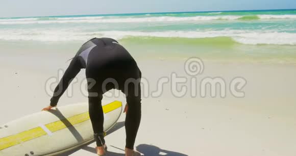 活跃的高加索男性冲浪者在阳光下海滩放松的后景视频的预览图