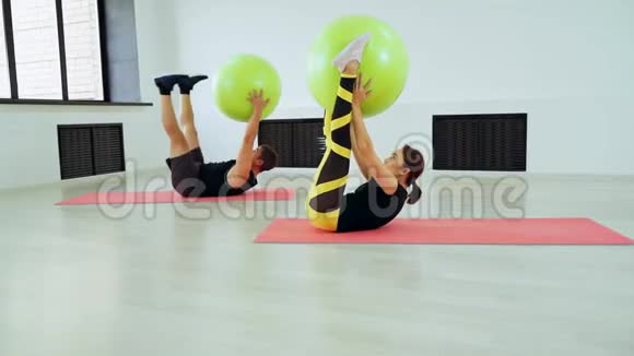 男人和女人用健身球在腹部肌肉上做运动视频的预览图