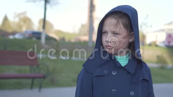 一个悲伤的少女的画像脸被烧焦在城市景观的背景下戴着头巾走在街上视频的预览图