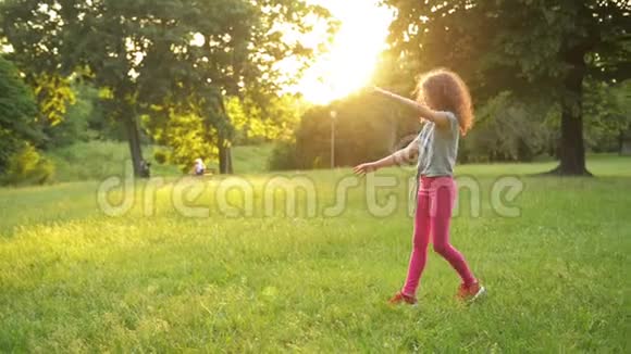 小女孩在绿色的草地上玩同时做一个杂技轮年轻的运动小子有一个非常好的心情视频的预览图
