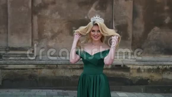 小姐金发碧眼穿着绿色连衣裙光着肩膀戴着皇冠摆姿势拍照视频的预览图