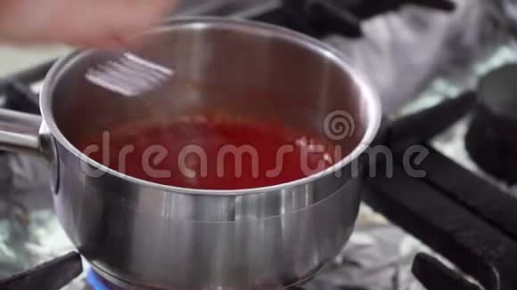 厨师把酱汁或糖霜放在平底锅里站在煤气炉上加热手动作特写视频的预览图