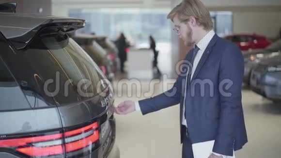 大胡子的商人选择汽车的汽车出现了近高个子男子手持平板电脑打开后备箱检查车辆视频的预览图